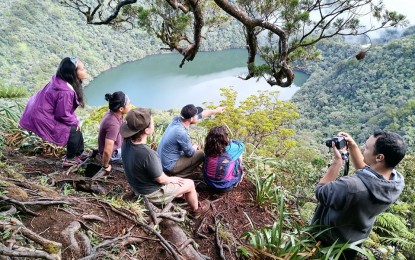 <p><strong>BIODIVERSITY</strong>. Trekkers take a breather and enjoy the view of Lake Nailig in Mt. Talinis in Valencia, Negros Oriental. The local government has decided not to re-open Mt. Talinis to trekkers to allow biodiversity to recover while formulating clear regulations for mountain climbing and other tourism activities in the area. <em>(Photo courtesy of Valencia LGU)</em></p>