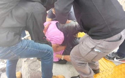 <p><strong>SLIPPERY YELLOW TILES</strong>. A Baguio City resident is being helped by passersby after slipping on the yellow tactile installed by the city government as part of its sidewalk improvement and rehabilitation project in this undated photo. Mayor Benjamin Magalong said they will stop the installation of the tactile even as he reiterated an earlier warning not to step on the tactile because these are intended only for the blind. <em>(PNA photo by Reyd Sigaw from Baguio City Times FB)</em></p>