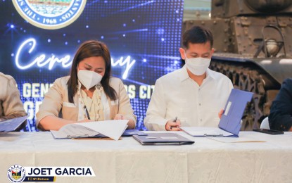 <p><strong>SISTERHOOD AGREEMENT</strong>. Bataan Governor Jose Enrique Garcia III (right) and General Santos City Mayor Lorelie Pacquiao (left) sign a sisterhood agreement on Thursday (Aug. 25, 2022) to advance cultural and trade linkages between the two localities. Garcia mentioned the similarity between Bataan and General Santos City in the aspects of agriculture, tourism, and natural resources that may contribute to sharing of unique strategies toward advancement and progress.<em> (Photo courtesy of the provincial government of Bataan)</em></p>