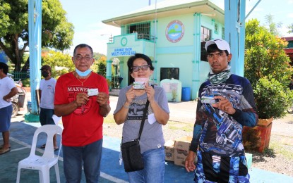 <p><strong>FUEL DISCOUNT CARDS</strong>. Qualified fishers in Candelaria, Zambales show the fuel discount cards that they received from the Department of Agriculture - Bureau of Fisheries and Aquatic Resources on Thursday (Aug. 25, 2022). A total of 430 fishers from the town received PHP3,000 in fuel subsidy each, which they could use to purchase gasoline for their fishing operations. <em>(Photo courtesy of BFAR-3)</em></p>