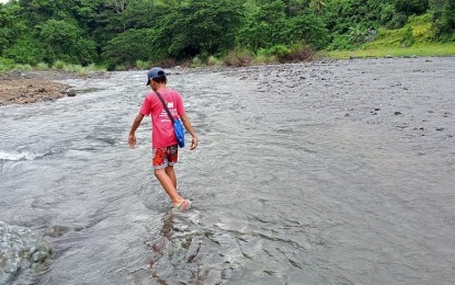 <p><strong>CROSSING THE RIVER</strong>. A learner from Barangay Latazon, Laua-an town crosses the Cairawan River to attend classes at the town proper in this photo taken on June 15, 2022. Abel Pedro, tribal leader of the indigenous peoples in the area, on Tuesday (Aug. 30, 2022) urges the provincial government to implement the construction of a new hanging bridge.<em> (Photo courtesy of Abel Pedro)</em></p>