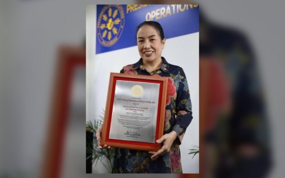 <p>S<strong>EAL OF EXCELLENCE.</strong> Press Secretary Trixie Cruz-Angeles shows the Selyo ng Kahusayan sa Serbisyo Publiko (Seal of Excellence in Public Service) received by the Office of the Press Secretary from the Komisyon ng Wikang Filipino (KWF) on Wednesday (Aug. 31, 2022). The OPS was one of the 29 government agencies and units that received the seal of excellence. <em>(Photo courtesy of the OPS)</em></p>