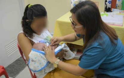 <p><strong>YOUNG MOM.</strong> A health worker attends to a young mother and her baby in this undated photo.  Teenage pregnancies in Negros Oriental in the 10-14 age bracket remained high over the past three years, health authorities said Thursday (Aug. 22, 2024). <em>(Photo lifted from the Commission on Population and Development Facebook page)</em></p>