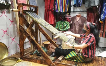 <p><strong>OTOP HUB</strong>. The Department of Trade and Industry and the ‘Layad di Kordilyera’, a group composed of craft artists and micro, small and medium enterprises (MSMEs), have opened a One Town, One Product (OTOP) booth at the Porta Vaga mall on Session Road, Baguio City where locally produced quality goods can be bought aside from viewing the tedious backstrap weaving process as shown in this undated photo. It is jointly financed by the entrepreneurs while the government continues to provide technical skills to further improve the system and products of the MSMEs.<em> (PNA photo by Liza T. Agoot)</em></p>