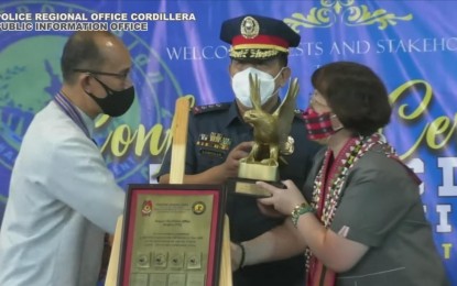 <p><strong>GOLD EAGLE AWARD</strong>. Baguio City Police Office (BCPO) director Col. Glenn Lonogan (center) and National Police Commission-Baguio Soledad Benwaren (right) receive the Philippine National Police’s Gold Eagle Award on Monday (Sept. 5, 2022) at Camp Dangwa in Benguet. Handing out the award is Baguio City Mayor Benjamin Magalong. <em>(PNA photo screenshot of the awarding shared on FB)</em></p>