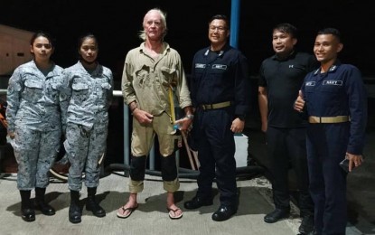 <p><strong>RESCUED.</strong> Australian Malcolm McIntyre, 57, (3rd from left) joins in a pictorial with his rescuers upon arrival at the Ensign Majini pier of the Naval Station Romulo Espaldon in Zamboanga City. Philippine Navy personnel rescued McIntyre while drifting at sea Monday evening (Sept. 5, 2022) near Sta. Cruz Island, Zamboanga City. <em>(Photo courtesy of the Naval Forces Western Mindanao)</em></p>