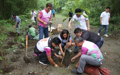 <p><strong>TREE PLANTING</strong>. Rotary Club president Richard "RG" Salazar (seated right) and Nayong Pilipino Foundation (NPF) Executive Director Gertie Duran-Batocabe (in blue striped shirt) join the tree planting activity at the NPF property in Parañaque City on Friday (Sept. 9, 2022). Project organizers said about 170 batino tree saplings would be planted in the area.<em> (PNA photo by Jess M. Escaros Jr.)</em></p>