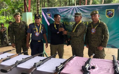 <p><strong>LOOSE FIREARMS.</strong> Mayor Talib Pawaki of Mohammad Ajul, Basilan (center) turns over 22 high-powered loose firearms to Brig. Gen. Domingo Gobway, 101st Infantry Brigade chief (2nd from right) in a ceremony Friday (Sept. 9, 2022) in Barangay Buton. Pawaki said the firearms were surrendered to him by residents of the different barangays in his town. <em>(Photo courtesy of the 101st Infantry Brigade)</em></p>