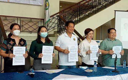 <p><strong>TIE-UP WITH HOSPITALS</strong>. Mayor Alfredo Abelardo Benitez (center), with (from left) Dr. Christine Marie Puey of Metro Bacolod Hospital and Medical Center, Cherry Pink Nonato of South Bacolod General Hospital, consultant for health insurance and health care Valerie Anne Hollero, and Councilor Claudio Jesus Puentevella, shows the signed memorandum of agreement for the indigent to avail of private hospital services under the Bacolod Comprehensive Health Program at the Government Center lobby on Thursday (Sept. 15, 2022). “(These) private hospitals will now accept BacCHP (card)holders without the need of any deposit (and) any other requirements they would ask patients before allowing them entry,” Benitez said.<em> (PNA photo by Nanette L. Guadalquiver)</em></p>
