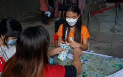 <p><strong>STUDENT PAYOUT.</strong> A learner receives her education assistance from a DSWD worker in this undated photo. More than 13,000 learners in Negros Oriental and Cebu provinces are set to receive the government aid on Saturday (Sept. 17, 2022), the DSWD in Region 7 said. <em>(Photo courtesy of DSWD-7) </em></p>