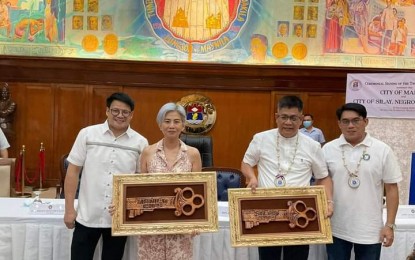 <p><strong>SISTER CITIES</strong>. Manila City Mayor Maria Sheillah "Honey" Lacuna-Pangan (2nd from left) and Vice Mayor John Marvin “Yul” Nieto (left), together with Silay City Mayor Joedith Gallego (2nd from right) and Vice Mayor Tom Ledesma, show the symbolic keys to their respective cities during the signing of the twinning agreement in rites held at the Manila City Hall on Thursday (Sept. 15, 2022). Gallego said the twinning agreement would greatly benefit Silay. <em>(Photo courtesy of Mayor Joedith C. Gallego’s Facebook page)</em></p>