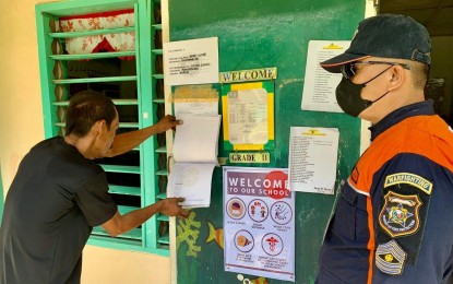 <p><strong>BASIC RIGHT.</strong> A resident looks up his name on the voters’ list while a Bureau of Fire Protection member is on standby during the Maguindanao plebiscite on Saturday (Sept. 17, 2022). Fire personnel were deployed to the towns of Sultan Mastura and Sultan Kudarat to assist voters. <em>(Courtesy of BFP-BARMM Sultan Kudarat Fire Station Facebook)</em></p>