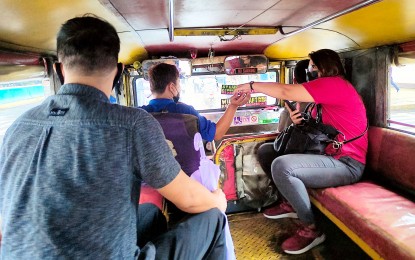 <p><strong>FARE MATRIX.</strong> A passenger pays her fare in a public utility jeepney in Quiapo, Manila on Sept. 19, 2022. The Land Transportation Franchising and Regulatory Board on Thursday said PUV operators may now request an updated matrix of new fare increases that will take effect on Oct. 3. <em>(PNA Photo Alfred Frias)</em></p>
