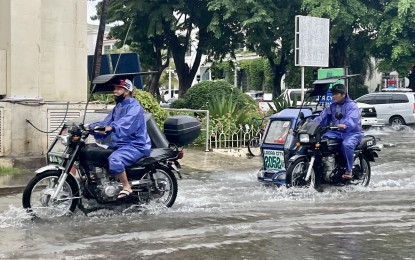 <p><strong>FARE HIKE</strong>. Tricycles wade through floodwaters in Laoag City in this undated photo. Soon, the minimum tricycle fare of PHP15 per passenger, up from PHP11, will be imposed to cushion the impact of oil price hike on drivers and operators.<em> (Photo by Leilanie Adriano)</em></p>