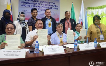 <p><strong>MOA SIGNING.</strong> Department of Transportation Undersecretary for Aviation and Airports Roberto Lim (center seated) and MOTC-BARMM Minister Dickson Hermoso (2nd left seated) pose with other officials after the memorandum of agreement signing on Wednesday (Sept. 21, 2022), which signals the transfer of the management of all airports in the region to the Bangsamoro Airport Authority. There are at least six airport facilities in BARMM, two of them non-operational. <em>(Photo courtesy of Bangsamoro Information Office - BARMM)</em></p>