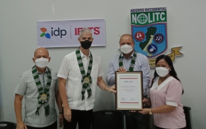 <p><strong>PARTNERSHIP</strong>. IDP country director Jose Miguel Habana (2nd from right) awards Governor Eugenio Jose Lacson (2nd from left), Vocational School Administrator Ma. Cristina Orbecido (right), and Provincial Administrator Rayfrando Diaz II the certificate designating the Negros Occidental Language and Information Technology Center as the official public test venue partner for the computer-delivered International English Language Testing System examination in Bacolod City on Thursday (Sept. 22, 2022). The awarding rites were held during the launching of the CD-IELTS shared laboratory at the NOLITC facility in the Negros First Cyber Centre. <em>(PNA photo by Nanette L. Guadalquiver)</em></p>