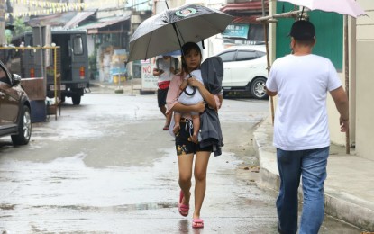 <p><strong>PRECAUTION.</strong> Mother and child leave their house along K-6th Street in Kamuning, Quezon City to transfer to a nearby evacuation center on Sunday (Sept. 25, 2022). The Quezon City Disaster Risk Reduction and Management Council has raised the red alert status in flood-prone areas due to the possible impact of Super Typhoon Karding. (<em>PNA photo by Robert Oswald P. Alfiler)</em></p>
