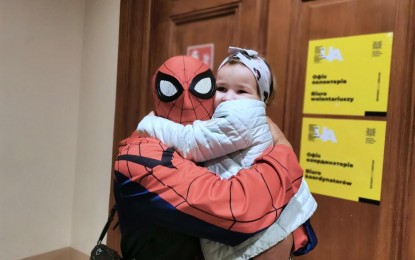 <p><strong>TURNING 'SPIDERMAN'.</strong> Mau Victa, a photojournalist based in Baguio City changes his outfit to become Spiderman to give joy to people, like this little girl in an evacuation center in Poland during a July 2022 visit sponsored by the European Union. Victa said the Spiderman mask is always in his bag and brings it out whenever necessary to lighten the mood or to bring out a smile from a sad face. <em>(PNA photo courtesy of Mau Victa)</em></p>