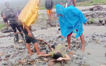 <p><strong>RETRIEVAL OPERATION</strong>. Rescuers recover on Monday (Sept. 26, 2022) the lifeless body of a woman who was carried away by flashfloods the night before in Barangay Bago, Tayasan town in Negros Oriental. The woman was crossing a river when she was swept downstream by raging waters caused by heavy rains due to Super Typhoon Karding and the southwest monsoon. <em>(Photo courtesy of the Negros Oriental Provincial Police Office)</em></p>