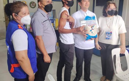 <p><strong>RICE INCENTIVE.</strong> Mayor John Dalipe (2nd from left) hands over a pack of five kilos of rice to a vaccinee after getting a booster dose on Monday (Sept. 26, 2022) in Zamboanga City. Dalipe announced that each vaccinee will receive five kilos of rice as an incentive during their weeklong vaccination activity.<em> (Photo courtesy of Zamboanga CIO)</em></p>