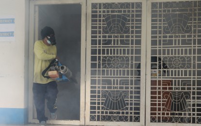 <p><strong>FOGGING OPERATIONS.</strong> A worker wears gas mask while carrying out fogging operations at the Mandaluyong City Hall compound in Mandaluyong City on Sept. 27, 2022. The country has recorded 299 dengue deaths from Jan. 1 to July 15 this year out of the total 80,318 cases.<em> (PNA photo by Joey O. Razon)</em></p>