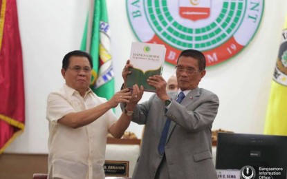 <p><strong>BANGSAMORO BUDGET.</strong> BARMM Chief Minister Ahod Ebrahim, assisted by Bangsamoro Transition Authority Speaker Pangalian Balindong, raises the proposed PHP85.2 billion for 2023 before parliament members on Monday (Sept. 26, 2022). The biggest chunk of the proposed budget goes to the social services sector, with a PHP36.9 billion allotment. <em>(Photo courtesy of Bangsamoro Information Office -BARMM)</em></p>