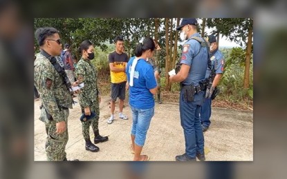 <p><strong>ARRESTED</strong>. Local police apprehend Michelle Penequito ( center), a former member of the New People’s Army wanted for murder and rebellion charges in an operation in Dumalag, Capiz province on Sept. 26, 2022. Penequito allegedly was among those behind the ambush of government troops at Barangay Switch, Tapaz, Capiz on Aug. 28, 2011. <em>(Photo courtesy of Capiz PNP)</em></p>