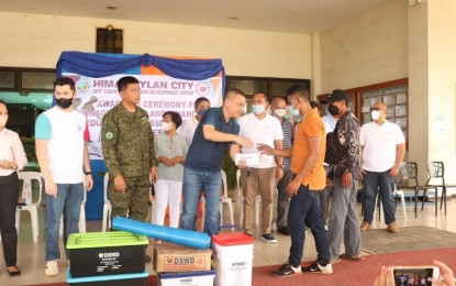 <p>G<strong>OVERNMENT ASSISTANCE</strong>. Mayor Rogelio Raymund Tongson Jr. of Himamaylan City, Negros Occidental turns over financial assistance to a former CPP-NPA rebel in rites held at the City Hall grounds on Sept. 27, 2022. Of the 25 recipients, 15 got cash aid worth PHP10,000 each while 10 others received PHP5,000 each. <em>(Photo courtesy of 94th Infantry Battalion, Philippine Army)</em></p>