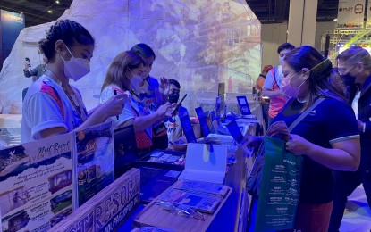 <p><strong>TRAVEL FAIR</strong>. People swarm the Ilocos Norte booth at the Philippine Travel Mart at the SMX Manila in Pasay City on Saturday (Oct. 1, 2022). Ilocos Norte Senior Tourism Officer Xavier Ruiz said the province generated PHP4,394,520 in sales during the three-day travel bazaar. <em>(Photo by Leilanie Adriano)</em></p>