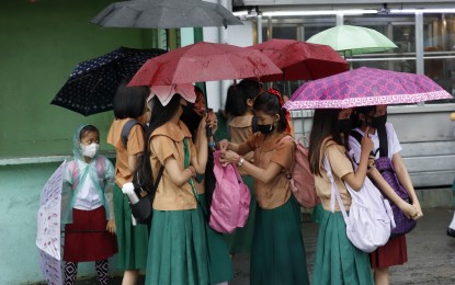<p><strong>RAINY WEDNESDAY.</strong> Students protect themselves from rain showers using umbrellas and raincoats in this undated photo. Ten provinces are under Tropical Cyclone Wind Signal No. 1 as Tropical Depression Amang brings rain showers on April 12, 2023. <em>(File photo)</em></p>