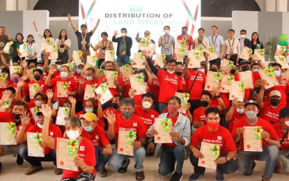 <p><strong>NEW OWNERS.</strong> A total of 124 Tarlac farmers receive Certificates of Land Ownership Award from the Department of Agrarian Reform in this July 2022 photo. Secretary Conrado Estrella III (arms raised, back row) led the event that also coincided with the distribution of machinery and equipment to Agrarian Reform Beneficiary Organizations and graduation of 32 farmers. <em>(Courtesy of Liana Barela/PIA 3)</em></p>