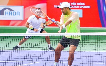 <p><strong>ON TARGET.</strong> Filipino tennis player Francis Casey Alcantara (right) returns the ball while Thai Pruchya Isa looks on during the men's doubles final of the Hai Dang Cup in Tay Ninh City, Vietnam on Oct. 2, 2022. They won the match, 2-6, 6-2, 10-3. <em>(Contributed photo)</em></p>