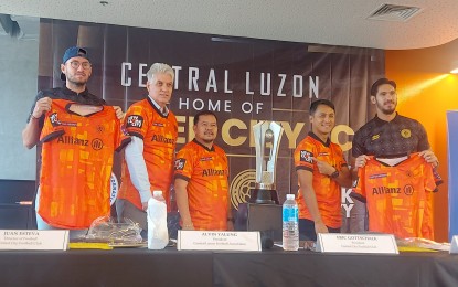 <p><strong>NEW JERSEY.</strong> United Clark president Eric Gottschalk (2nd from left), players JJ Robertson (left) and Mark Hartmann (right), Central Luzon Football Association president Alvin Yalung (center), and Bases Conversion and Development Authority senior vice president Arrey Perez (2nd from right) unveil the club's new jersey on Tuesday (Oct. 4, 2022) ahead of its upcoming home stand at the New Clark City Athletic Stadium in Capas, Tarlac later this month. United Clark is the reigning Philippines Football League (PFL) champion. <em>(PNA photo by Ivan Saldajeno)</em></p>