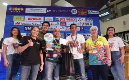 <p><strong>WINNER</strong>. Caviteño cue artist Jundel Mazon (center) wins the 1st Mayor Albee Benitez Masskara Billiards Tournament after a five-day competition at SM City Bacolod on Thursday night (Oct. 6, 2022). He received the champion’s prize of PHP350,000 from festival director Pinky Mirano-Ocampo (2nd from left) during the awarding rites held after the finals match. <em>(Photo courtesy of Bacolod Yuhum Foundation)</em></p>