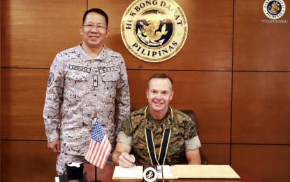 <p>Philippine Navy Chief-of-Naval Staff, Commodore Jose Ma. Ambrosio Ezpeleta (standing) and  United States 3rd Marine Division commander Maj. Gen Jay Bargeron (center) <em>(Photo courtesy of Philippine Navy)</em></p>