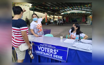 <p><strong>GOING TO THE POLLS</strong>. A woman asks for directions from the Voters' Assistance Desk as Ormoc City holds a plebiscite for the merger of its 28 barangays on Saturday (Oct. 8, 2022). Commission on Elections Commissioner George Erwin Garcia and three other commissioners supervised the plebiscite. (Photo by Roel Amazona) </p>