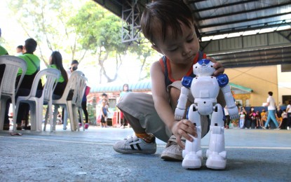 <p>A child plays with his toy robot. <em>(PNA photo by Robert Oswald P. Alfiler)</em></p>