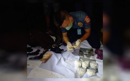 <p><strong>SEIZED</strong>. A police officer examines pieces of evidence seized from Roberto Dela Cruz who was arrested for evading a checkpoint at Barangay Bailan in Pontevedra, Capiz but later on was found to be carrying over PHP4 million worth of shabu in his bag Monday evening (Oct. 10, 2022). Police Regional Office 6 spokesperson Maj. Grace Borio, in an interview on Tuesday (Oct. 11, 2022) said the accomplishment is one of their biggest hauls from Oct. 3-10.<em> (PNA photo courtesy of Pontevedra Capiz Pulis)</em></p>