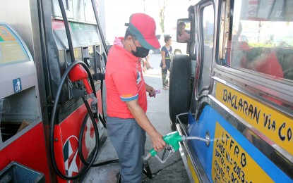 <p>A gas station attendant refills the gas tank of a passenger jeepney.<em> (File photo)</em></p>