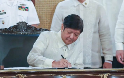 <p><strong>SIM CARDS REGISTRATION LAW.</strong> President Ferdinand “Bongbong” Marcos Jr. signs Republic Act No. 11934 also known as An Act Requiring the Registration of SIM Cards in a ceremony at Malacanan Palace on Monday (Oct. 10, 2022). The new law aims to regulate the release of SIM Cards to curb the proliferation of text message scams in the country.<em> (Photo courtesy of Bongbong Marcos FB page)</em></p>