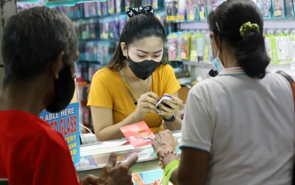 <p><strong>NEW SIM.</strong> A shop attendant assists a customer who bought a SIM card at a mobile phone and accessories store in Farmers Plaza, Quezon City on Tuesday (Oct. 11, 2022). Information and Communications Technology Secretary Ivan John Uy said the newly-signed SIM registration law will affect SIM cards from local telecommunications companies, including those using their roaming services overseas. <em>(PNA photo by Robert Oswald P. Alfiler)</em></p>