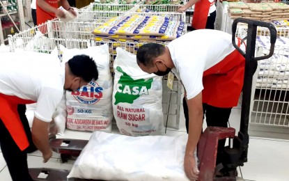 <p>Baggers hauling sacks of sugar at a supermarket. <em>(File photo)</em></p>