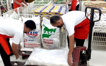 <p><strong>13TH MONTH PAY. </strong>Workers haul sacks of sugar at a supermarket in this undated photo. Labor Secretary Bienvenido Laguesma said private sector employers are mandated to pay the benefits due to their workers, which is equivalent to an employee’s one-month salary. <em>(PNA file photo)</em></p>