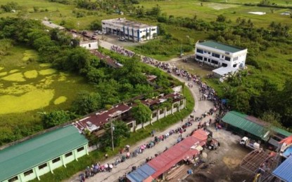 <p><strong>CASH AID</strong>. A drone shot of the long queue near the Department of Social Welfare and Development (DSWD) office in Palo, Leyte during the distribution of cash assistance to poor students on Aug. 20, 2021. At least 29 in every 100 individuals in Eastern Visayas remain poor or have income below the amount needed to buy their basic needs, the Philippine Statistics Authority reported on Friday (Oct. 14, 2022). <em>(DSWD photo)</em></p>