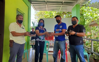 <p><strong>STARTER KIT</strong>. Kapalong town Mayor Maria Theresa Timbol (2nd from left) hands over on Friday (Oct. 14, 2022) the free-range chicken to James Juan Sab (2nd from right), one of the Technical Education and Skills Development Authority (TESDA) graduates of Animal Production (Poultry Chicken) NC II. Sab is one of the 24 successful graduates who received five free-range chickens each for their livelihood. <em>(PNA photo by Che Palicte)</em></p>