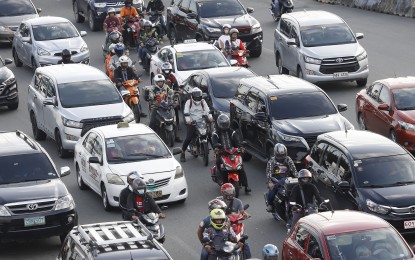 <p><strong>MOTORCYCLE ACADEMY</strong>. Motorcycle riders squeeze between larger vehicles along Commonwealth Avenue in Philcoa, Quezon City on Oct. 17, 2022. The Metropolitan Manila Development Authority on Monday (Jan. 23) announced plan to establish a motorcycle riding academy to decrease motorcycle accidents. <em>(PNA file photo)</em></p>