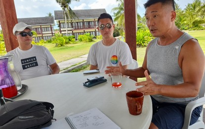 <p><strong>SURFING SISTERHOOD.</strong> Jason Ha (right) translates the explanations of Councilor Jongsuk Lee (left) of Yangyang City, South Korea, and Young Kwon (center), the chair of Surfstar organization in the same city, on the important features of the sisterhood agreement between their city and General Luna town in Siargao Island. The friendship between the two local governments, both dubbed as surfing capitals in their respective countries, is expected to strengthen cooperation in surfing events and tourism activities. <em>(PNA photo by Alexander Lopez)</em></p>