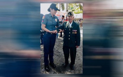 <p><strong>WAR HERO</strong>. A police officer assists a World War II veteran in Leyte province in this Oct. 19, 2019 photo. With only 30 World War II veterans alive in this year’s Leyte Gulf Landings commemoration, the Leyte provincial government is working on preserving their stories as a tourism asset. <em>(Photo courtesy of Lanlan Lacanaria)</em></p>