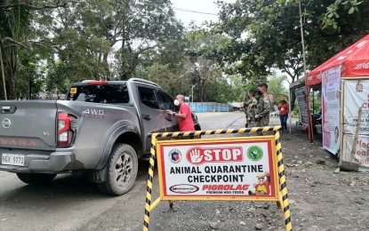 <p><strong>BORDER CONTROL</strong>. A staff of the Antique Provincial Veterinary (ProVet) Office flags down a private vehicle in Barangay Fabrica, Hamtic where a border control checkpoint operates 24/7 as a measure to prevent the entry of pork and pork by-products from African swine fever-affected areas. ProVet Public Health Division chief Dr. Marco Rafael Ardamil said on Friday (Oct. 21, 2022) that the 24-7 border control in the province has been in effect since Thursday (Oct. 20). <em>(Photo courtesy of Antique ProVet)</em></p>