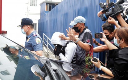 <p><strong>PROBE.</strong> Policemen escort Joel Escorial, self-confessed gunman in the Percy Lapid slay case, into the Department of Justice compound in Manila on Monday (Oct. 24, 2022). The  first preliminary investigation hearing was held to determine the facts behind the slay of the broadcaster on October 3. <em>(PNA photo by Benjamin Pulta)</em></p>